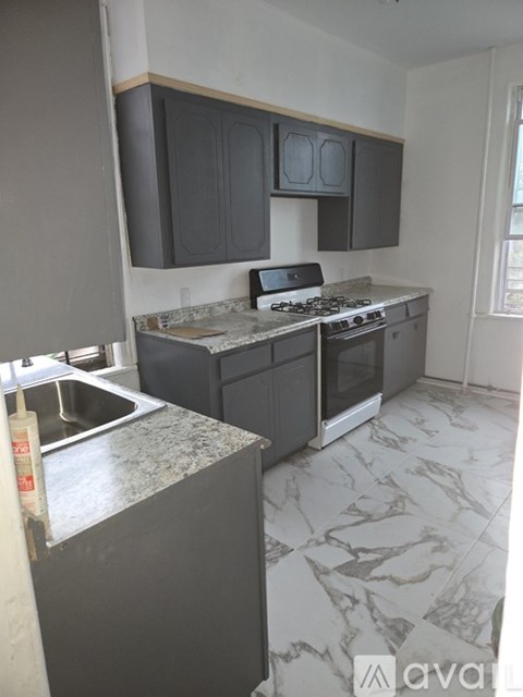 A kitchen with a marble countertop and a stove top oven.