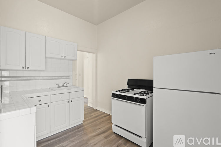 A kitchen with white appliances and cabinets.