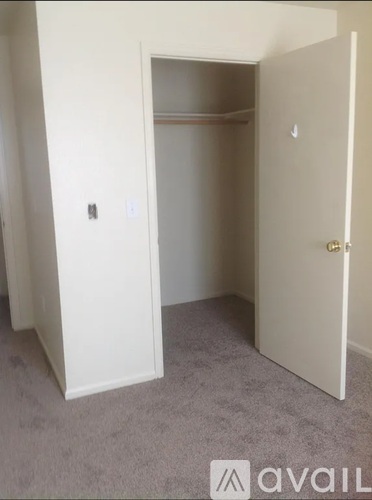 A white door is open to a carpeted room.