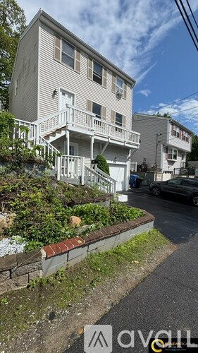 A house with a white exterior and a balcony on the second floor.