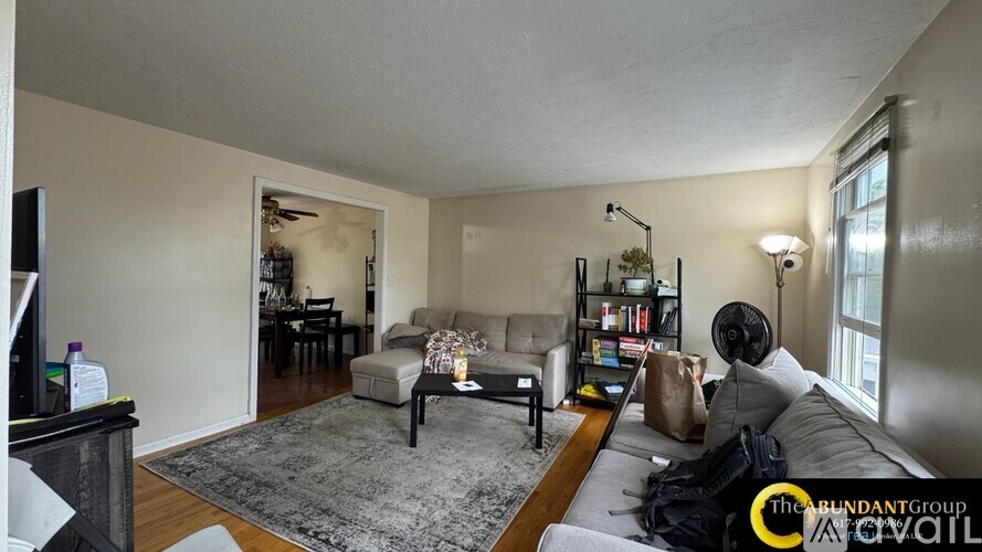 A living room with a grey couch, a black coffee table, a fireplace, and a bookshelf.