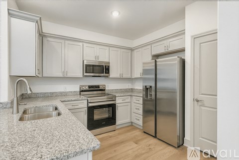 A kitchen with a granite countertop and stainless steel appliances.