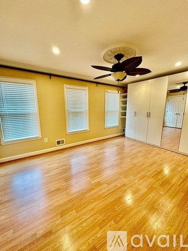 A room with wooden floors and a ceiling fan.
