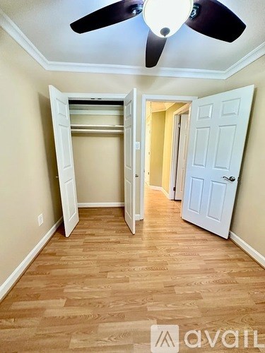 A room with a ceiling fan and a white door.