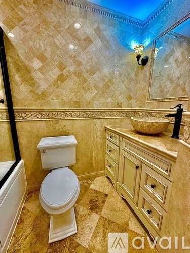 A bathroom with a toilet, sink, and a mirror.
