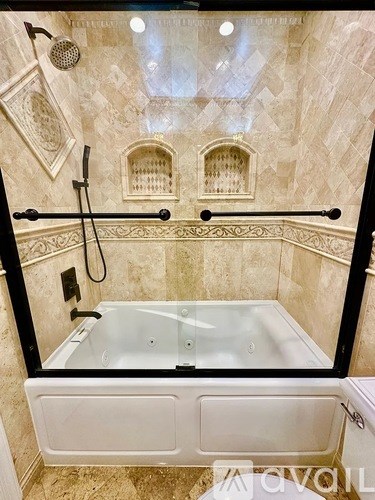 A bathroom with a glass shower door and a glass tub.