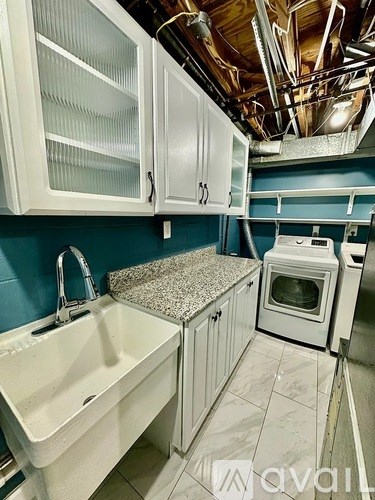 A kitchen with white cabinets and a white sink.