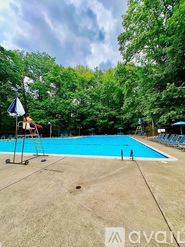 A person is sitting on a chair by a pool.