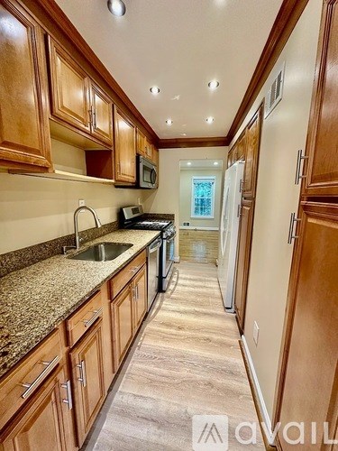 A kitchen with wooden cabinets and granite countertops.