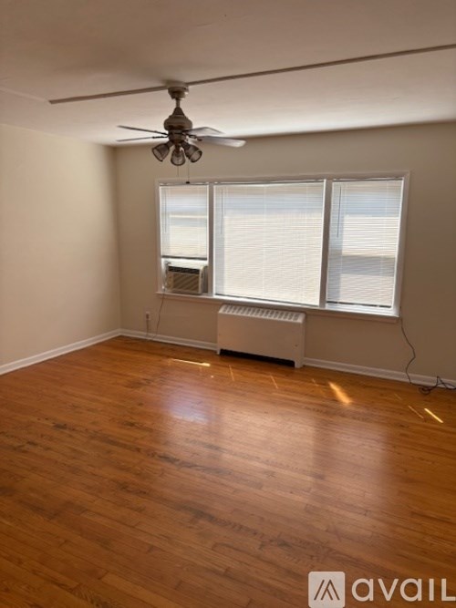 A room with wooden floors and a ceiling fan.