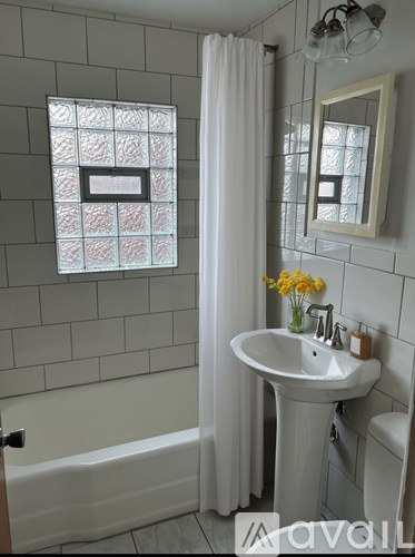 A white bathroom with a white sink and a white tub.