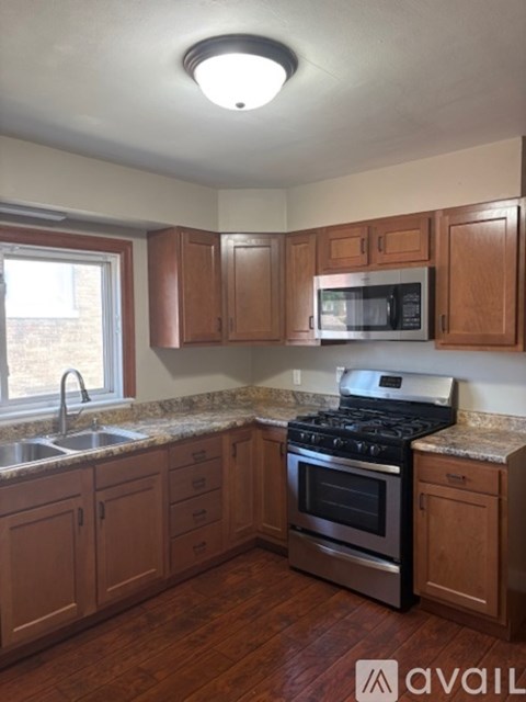 A kitchen with wooden cabinets and a granite countertop.
