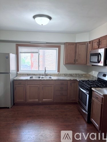 A kitchen with wooden cabinets and a window.