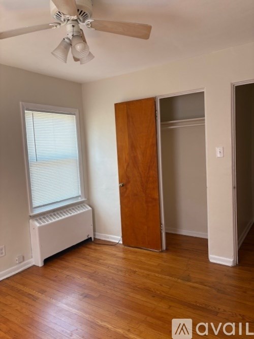 A room with a ceiling fan and a window with blinds.