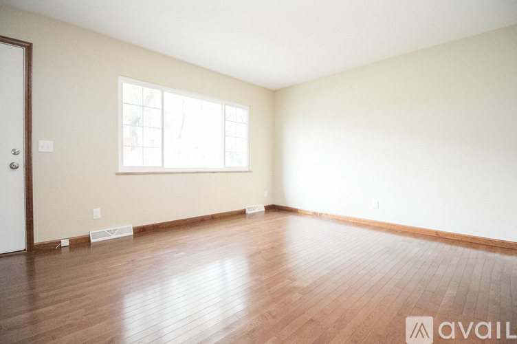 A room with wooden flooring and a window.