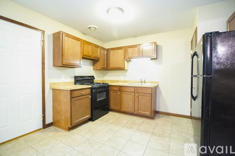 A kitchen with wooden cabinets and black appliances.
