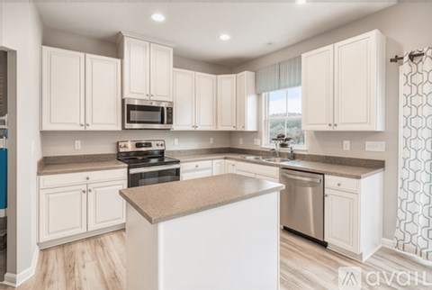 A kitchen with white cabinets and a granite countertop.