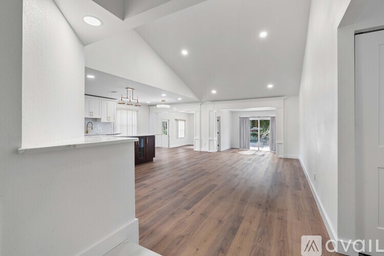 A spacious room with wooden floors and white walls.