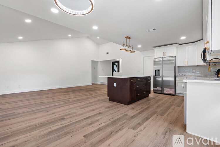 A kitchen with wooden floors and white walls.