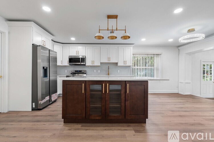 A kitchen with white cabinets and a wooden island.