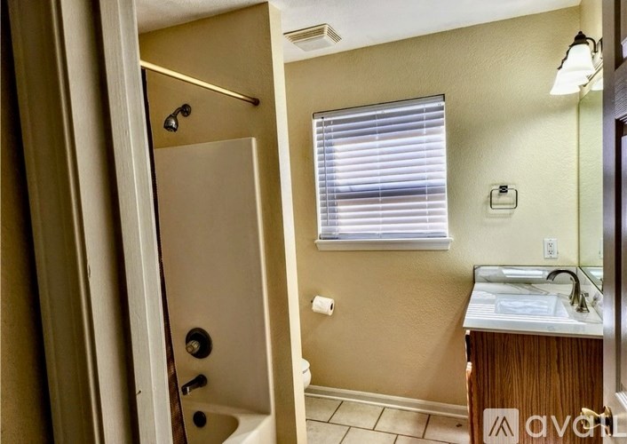 A bathroom with a toilet, sink, and window.
