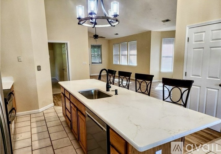 A kitchen with a marble countertop and a chandelier.