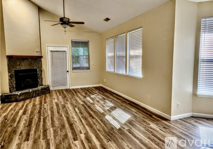 A living room with a fireplace and wood flooring.