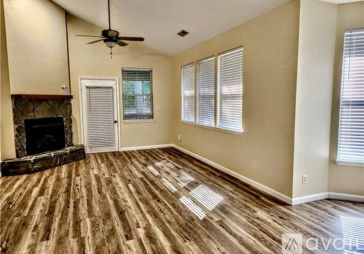 A living room with a fireplace and wood flooring.