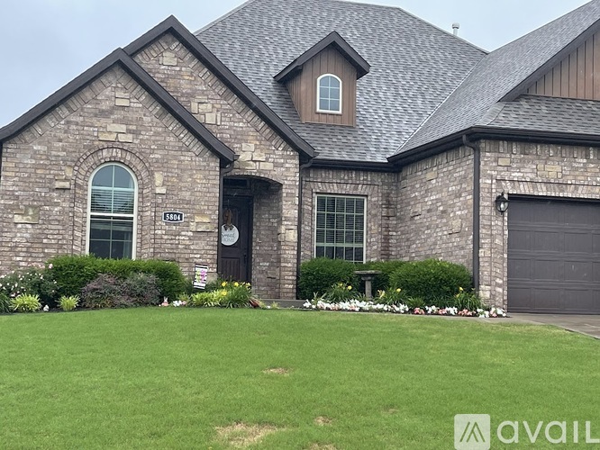 A house with a stone facade and a garage door.