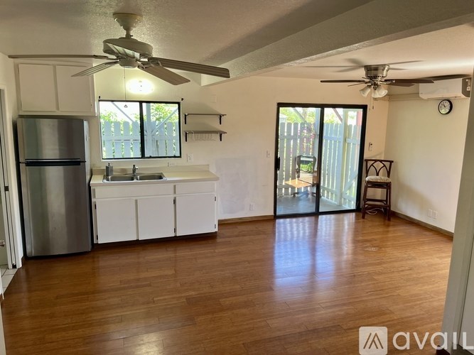 A kitchen with white cabinets and a stainless steel refrigerator.