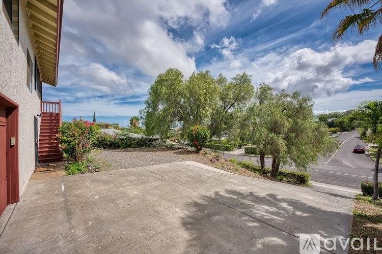 A house with a driveway and trees in the background.