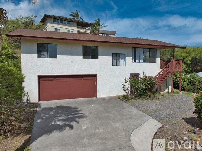 A white house with a red garage door and a red staircase.
