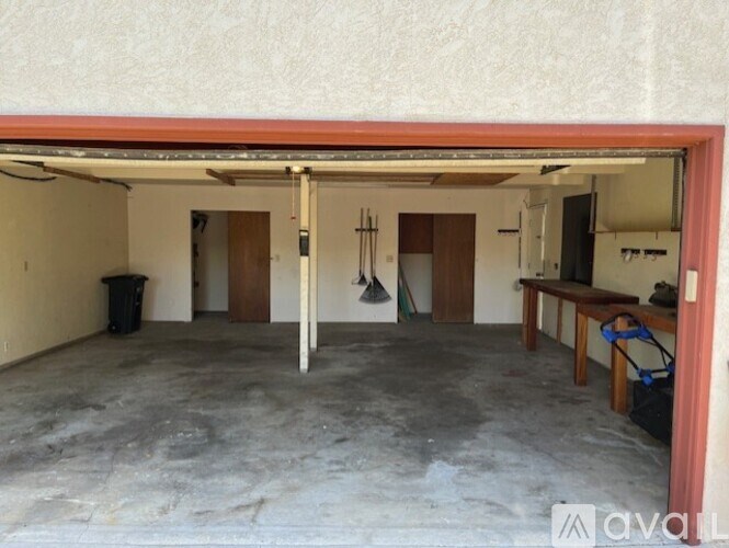 A garage with a concrete floor and a red-painted door frame.