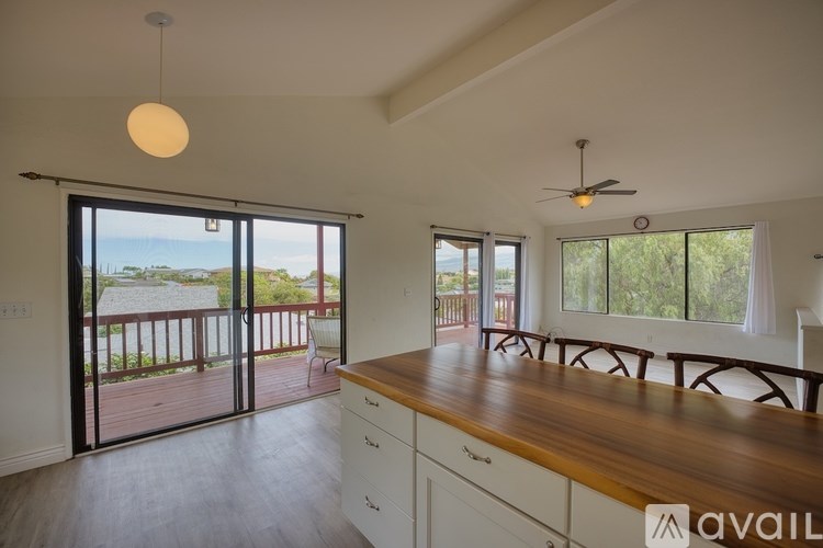 A kitchen with a wooden countertop and a view of the outdoors through the sliding glass doors.