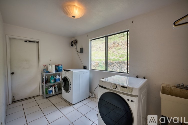 A laundry room with a washer and dryer, a window, and a door.