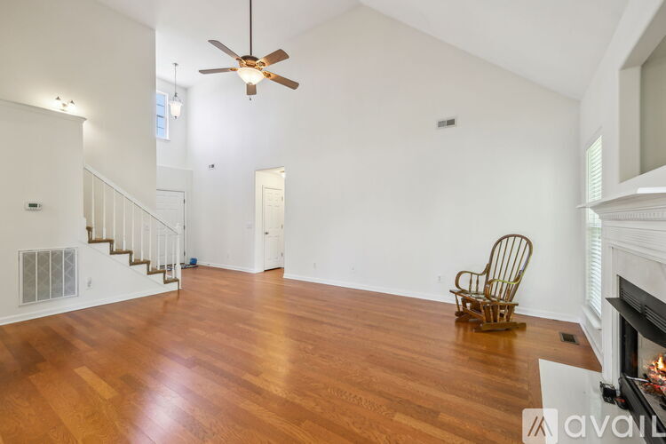 A living room with a wooden floor and a rocking chair.