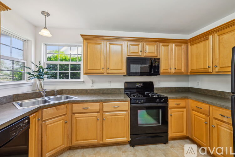 A kitchen with wooden cabinets and a black stove top oven.