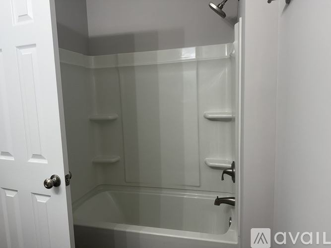 A white bathroom with a glass shower door and a white door.