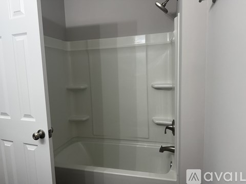 A white bathroom with a glass shower door and a white door.