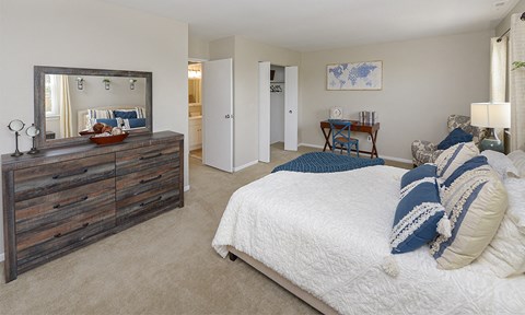 a bedroom with a bed and a dresser and a mirror