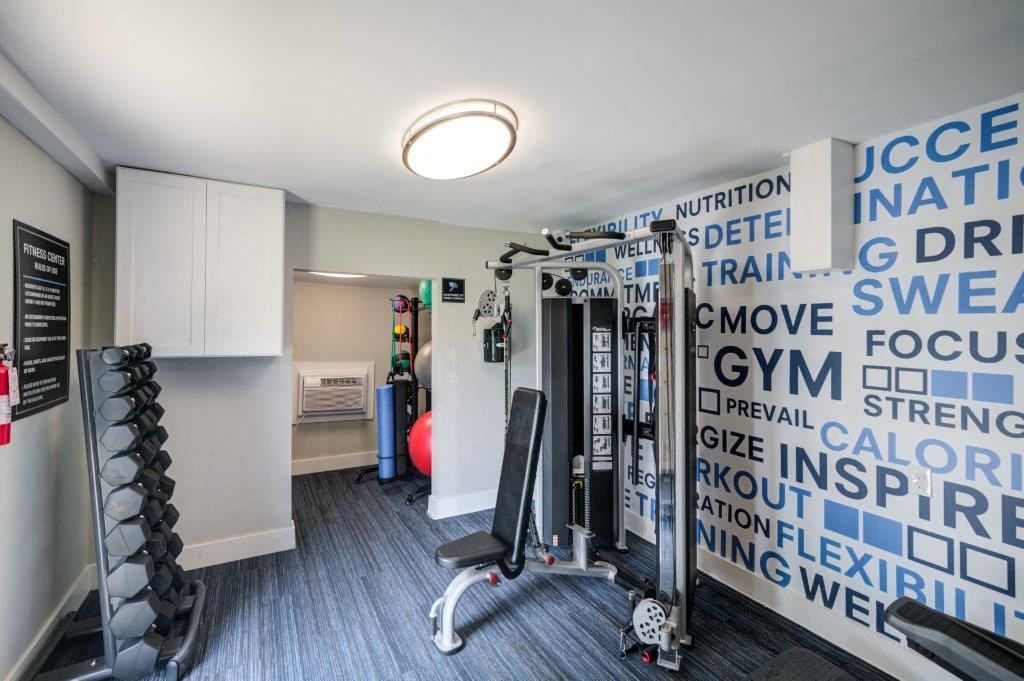 a gym with weights and a wall with words on it