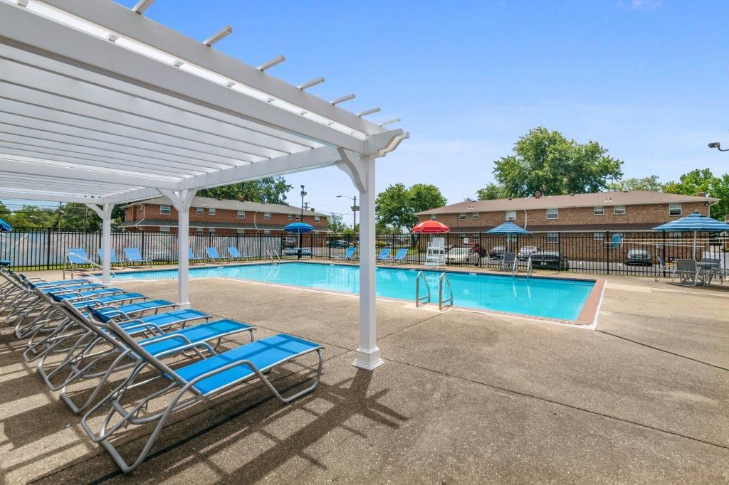 a pool with blue chairs and a white canopy