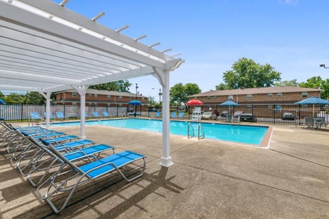 a pool with blue chairs and a white canopy