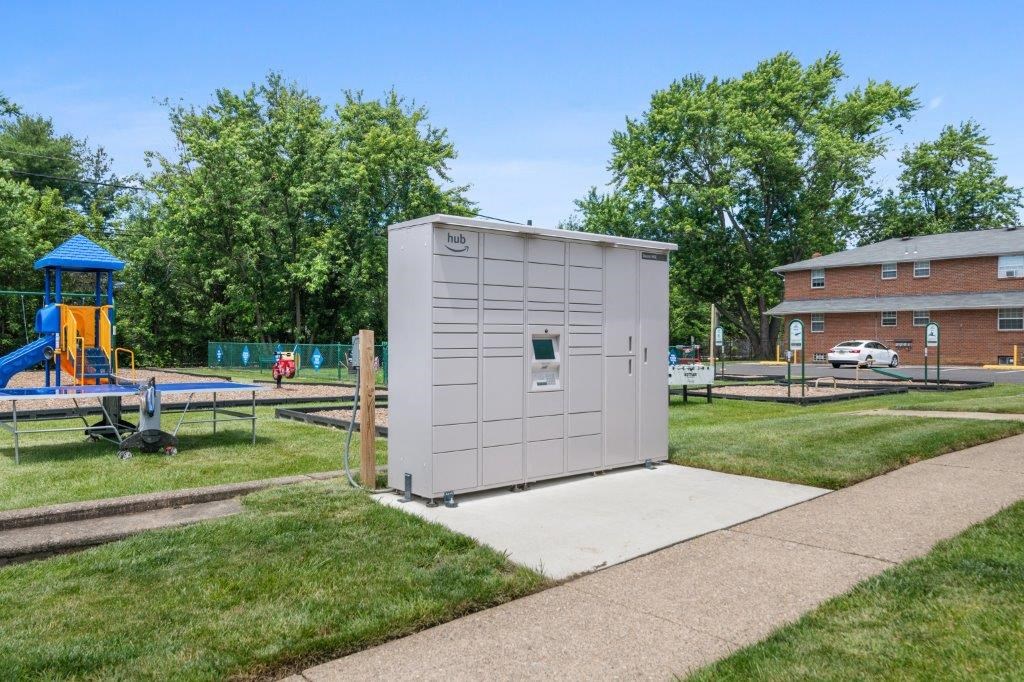 a small building sitting on a sidewalk next to a playground