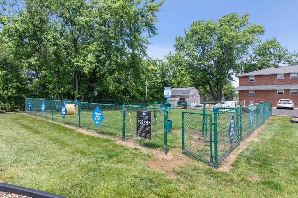 a park with a fence and a building behind it