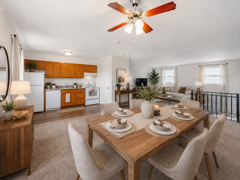 A dining room with a table set for six with a fan in the ceiling.