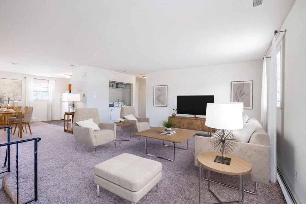 a living room with a couch and chairs and a television