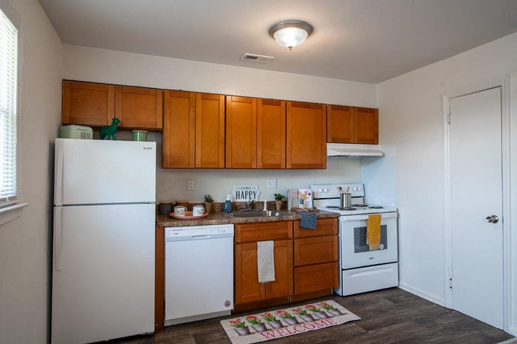 a kitchen with white appliances and wooden cabinets