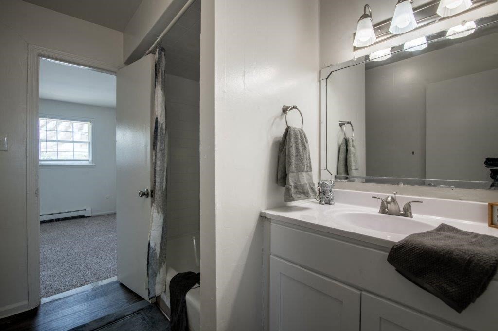 a white bathroom with a sink and a mirror