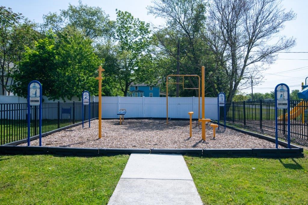 a playground with swings and a fence in a park
